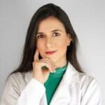 Portrait of a female healthcare professional in a white lab coat in a studio setting.